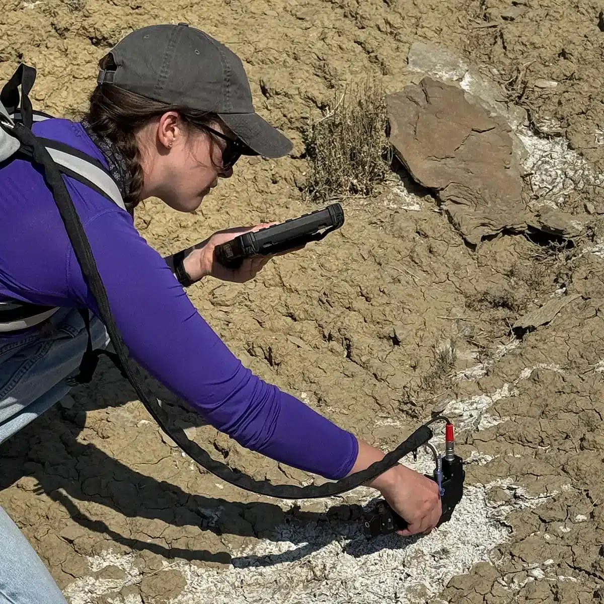 Sara Shields taking research readings from a rocky terrain