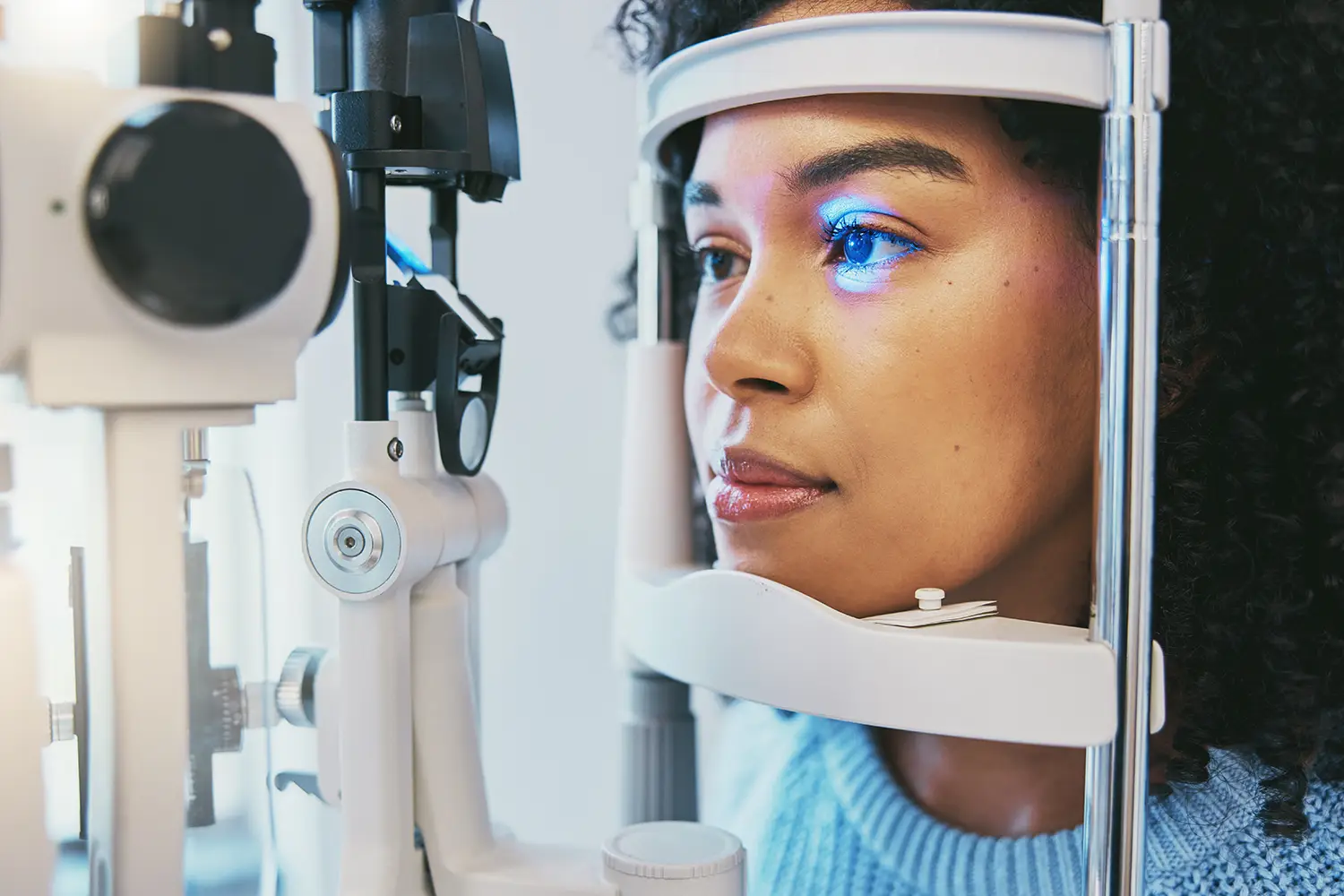A woman looks into a scanner in an optometrist's office