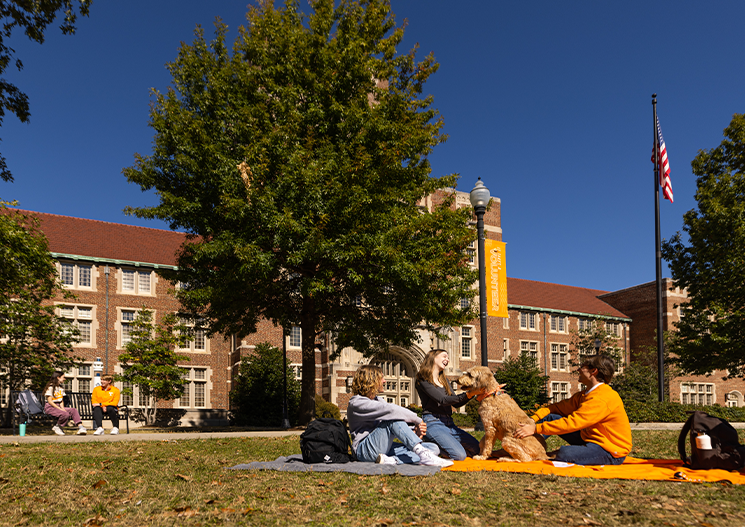Students hangout on blankets with a dog on Ayres lawn on October 20, 2022. Photo by Steven Bridges/University of Tennessee.