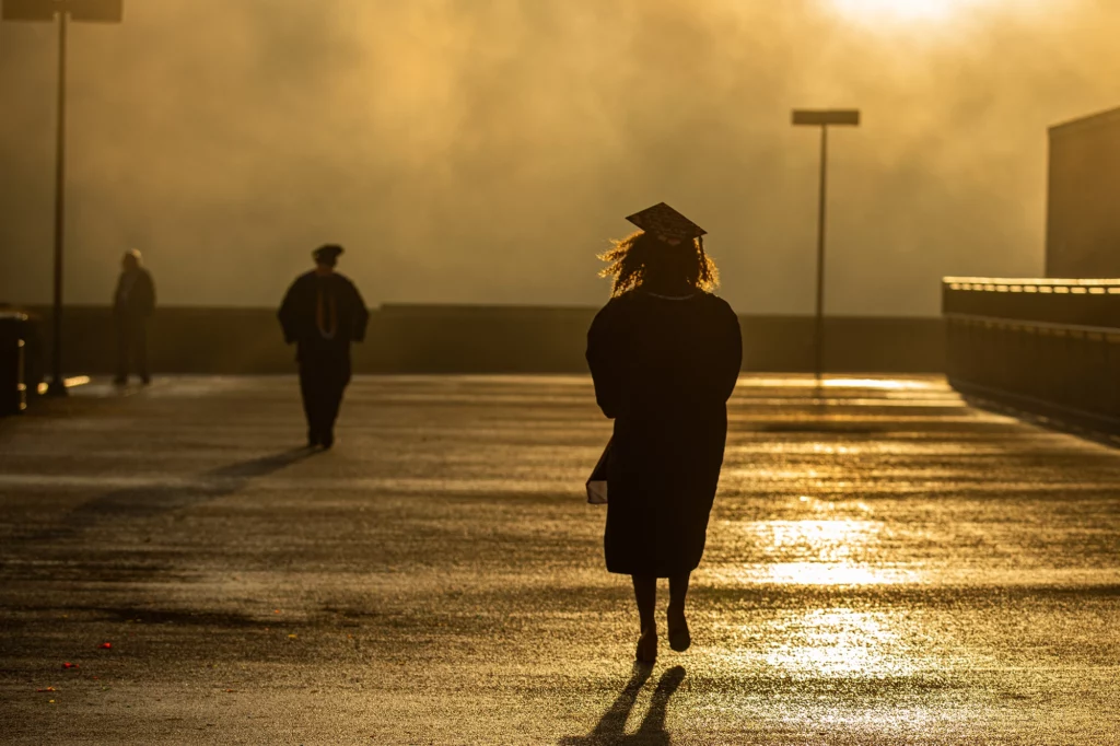 Graduate walking through a parking lot