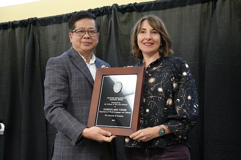 Florence Abad Turner accepts an award from Liem Tran at the Arts & Sciences Faculty Awards Ceremony in 2024