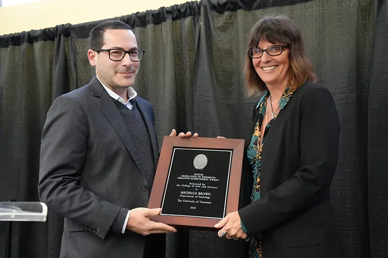Michelle Brown accepts an award from Michael Blum at the Arts & Sciences Faculty Awards Ceremony in 2024