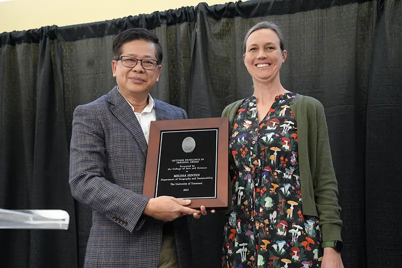 Melissa Hinten accepts an award from Liem Tran at the Arts & Sciences Faculty Awards Ceremony in 2024