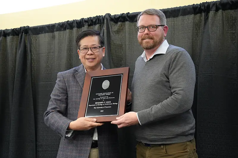 Benjamin Keck accepts an award from Liem Tran at the Arts & Sciences Faculty Awards Ceremony in 2024
