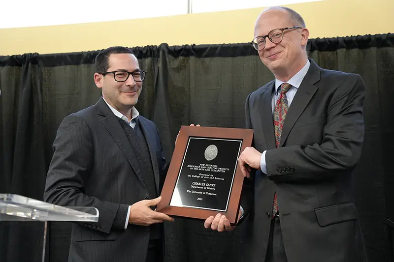 Charles Sanft accepts an award from Michael Blum at the Arts & Sciences Faculty Awards Ceremony in 2024