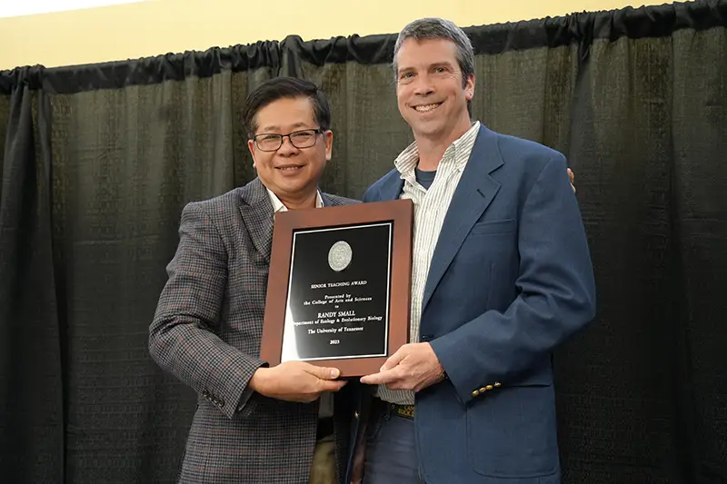 Randy Small accepts an award from Liem Tran at the Arts & Sciences Faculty Awards Ceremony in 2024