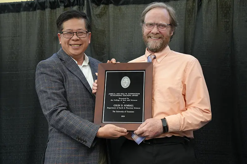 Colin Sumrall accepts an award from Liem Tran at the Arts & Sciences Faculty Awards Ceremony in 2024