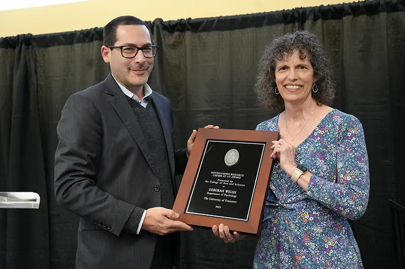 Deborah Welsh accepts an award from Michael Blum at the Arts & Sciences Faculty Awards Ceremony in 2024
