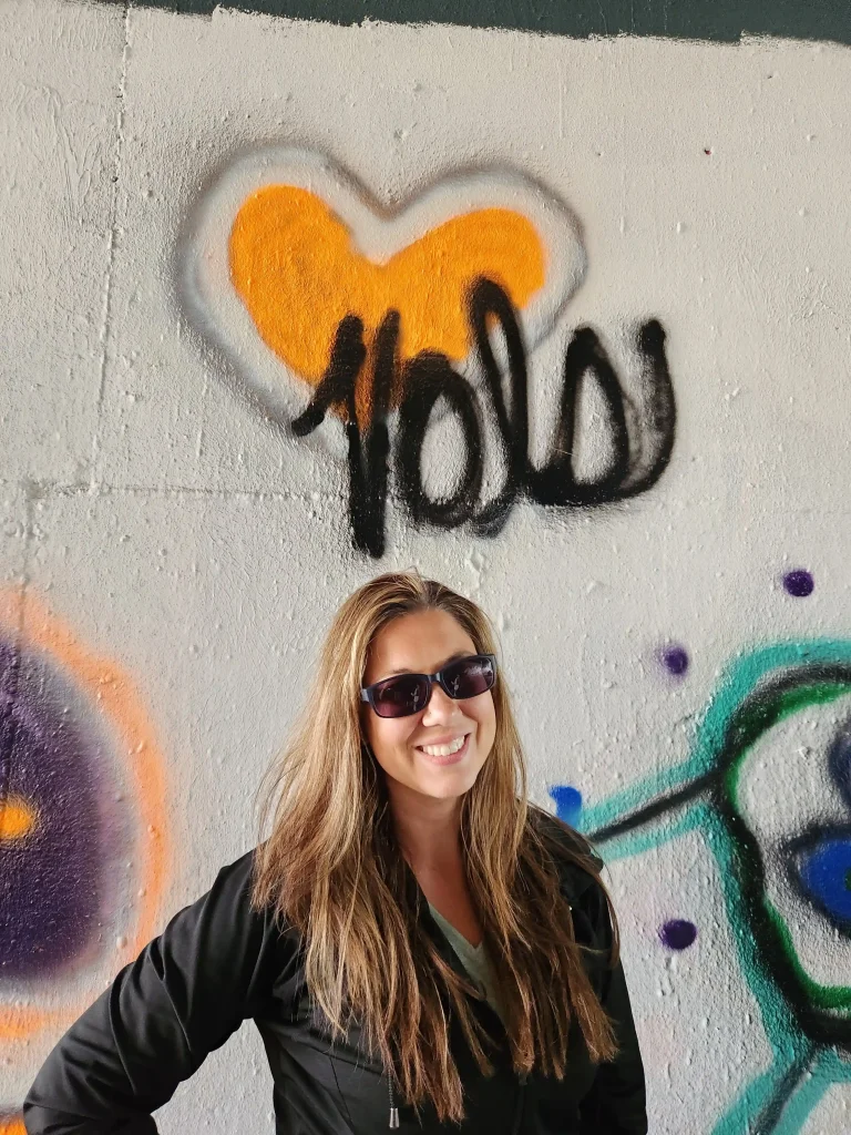 Jade Pfiester in sunglasses beside her design during a street art class in Frieburg, Germany, part of the study abroad.