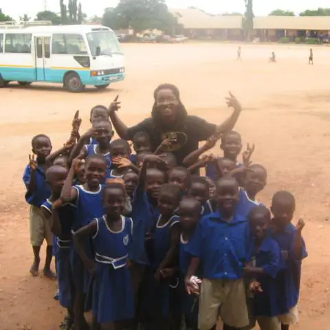 Corey A. Hodge poses for a photo with students from a school in Ghana