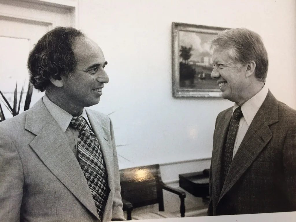 A black and white photo showing S. David Freeman talking with President Jimmy Carter