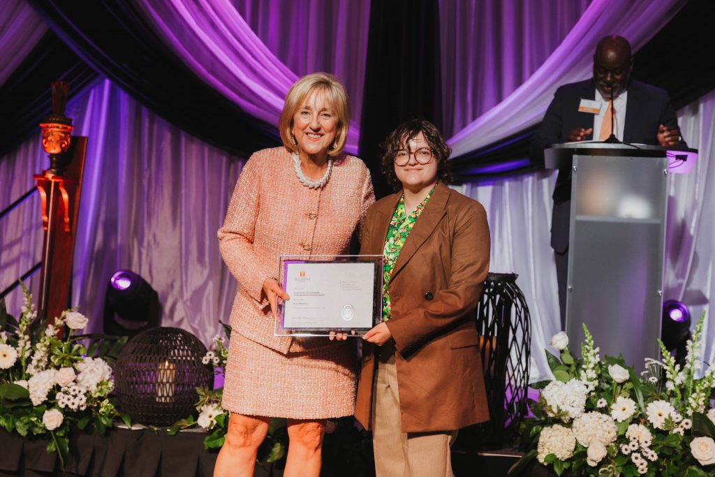 University of Tennessee Chancellor Donde Plowman presents the Commission for Disability Undergraduate Student Award to Evan Shannon for furthering recognition of and support for disabled people at UT. 