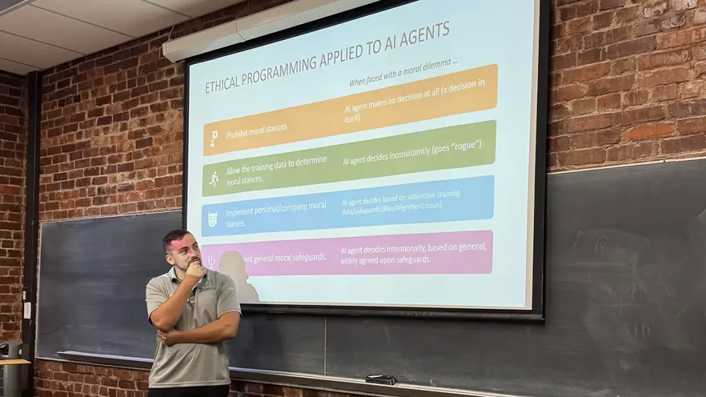 A student making a powerpoint presentation with a brick wall behind the projector screen