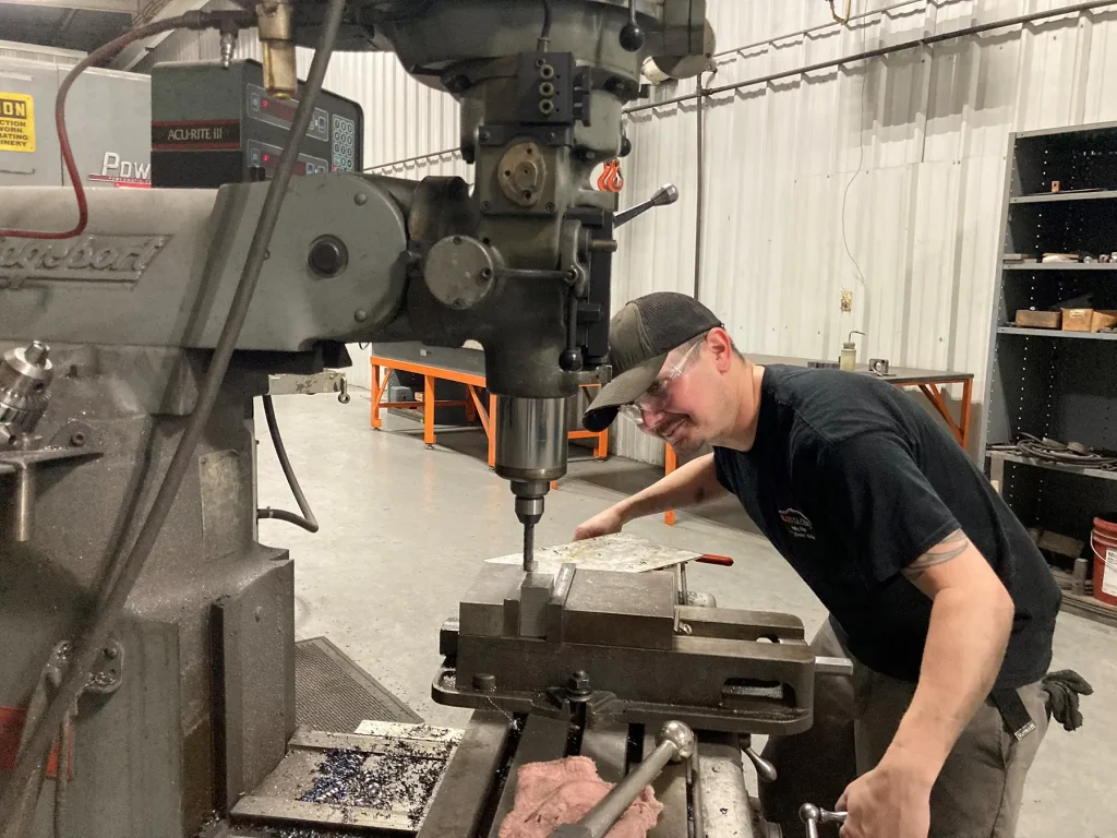  Tool and die apprentice Ty Cobb works at the TELOS Global plant in Caryville, Tennessee, which manufactures parts for electric vehicles. The University of Tennessee, Knoxville, is partnering with TELOS and other employers in advanced manufacturing and green construction industries on East Tennessee Works, a green jobs initiative.
