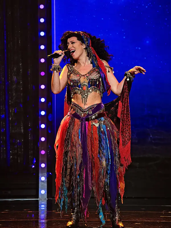 A woman singing onstage in an elaborate costume