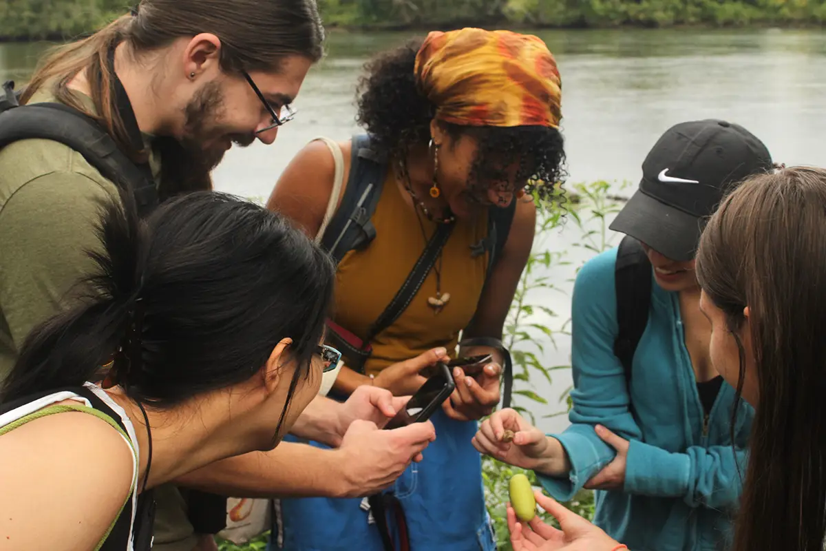 Naturalist Club gathered in a circle with water behind them