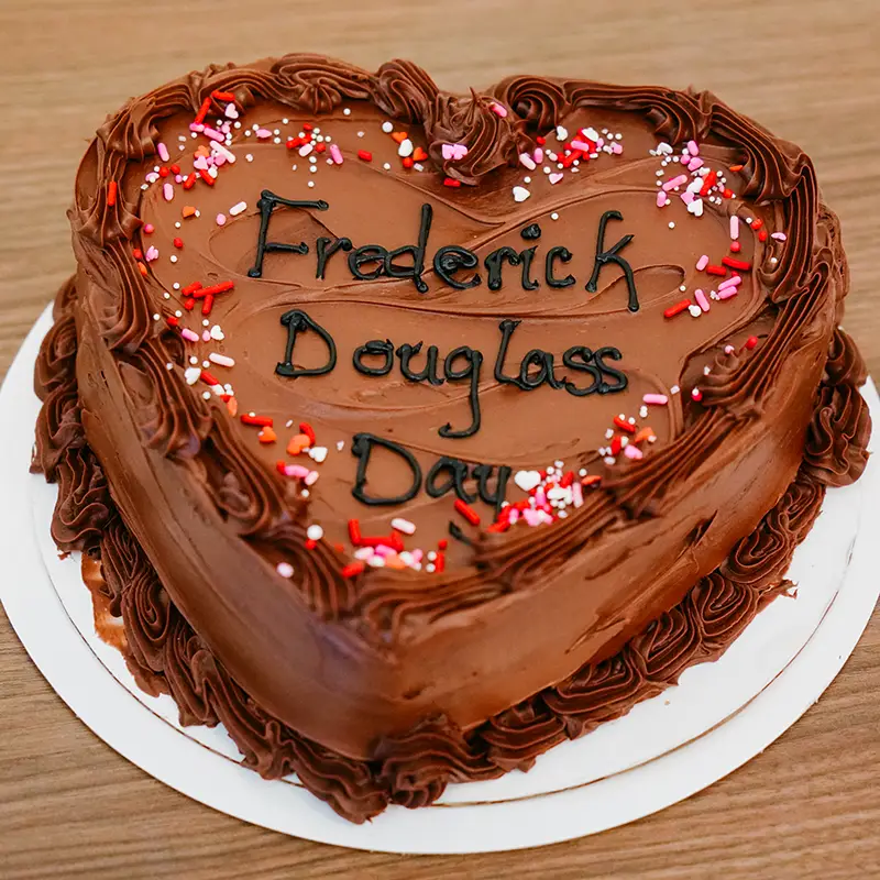 A heart shaped cake with the words Frederick Douglass Day on it