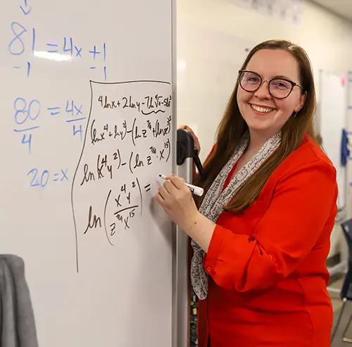 Emily McDonald write equations on a white board