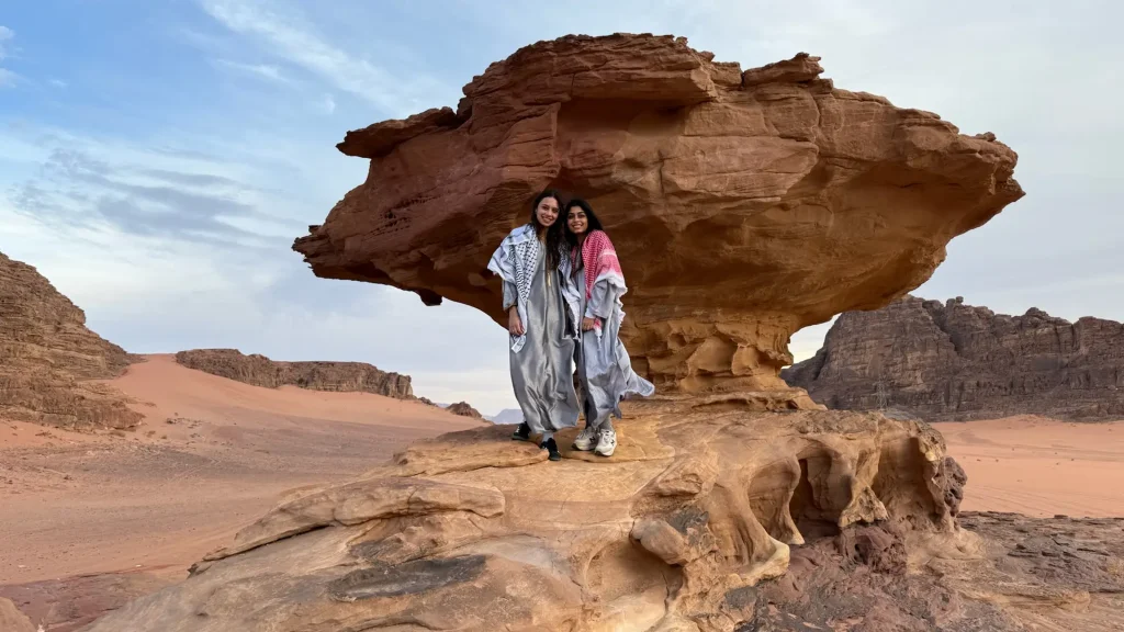 Two students posing for a photo in front of a rock formation