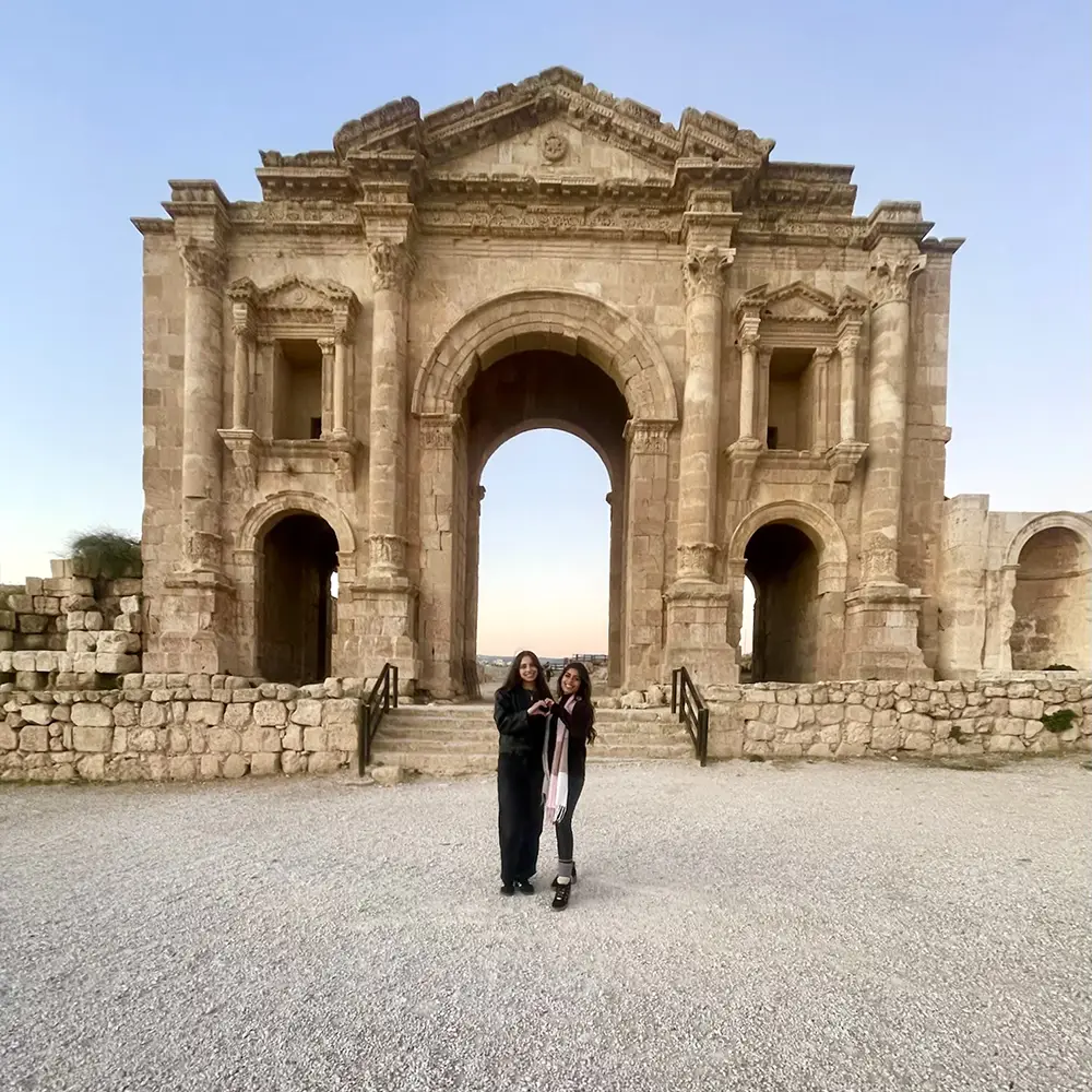 Students posing for a photo in front of an ancient structure