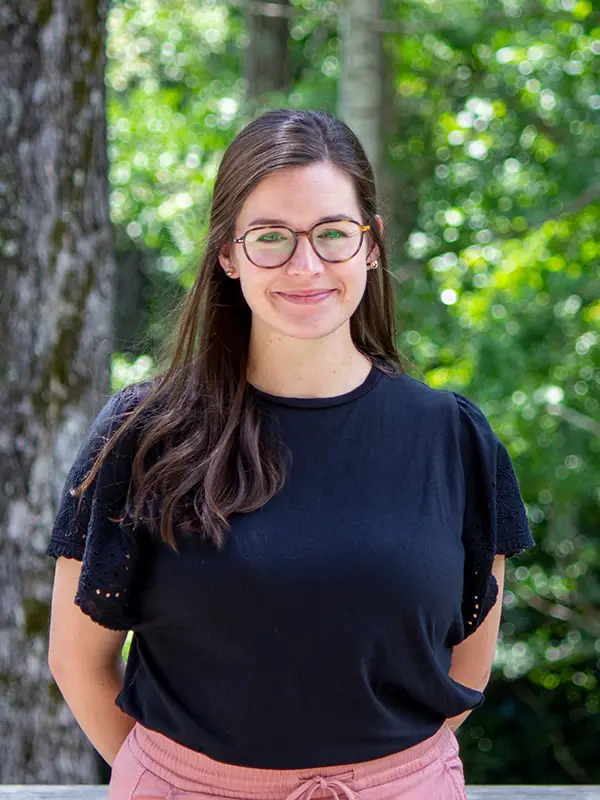 Outdoor headshot photo of a woman wearing glasses