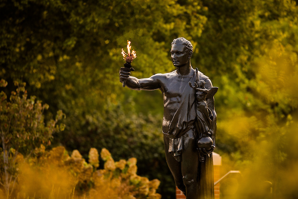 The University of Tennessee's torchbearer statue stands early in the morning holding a torch.