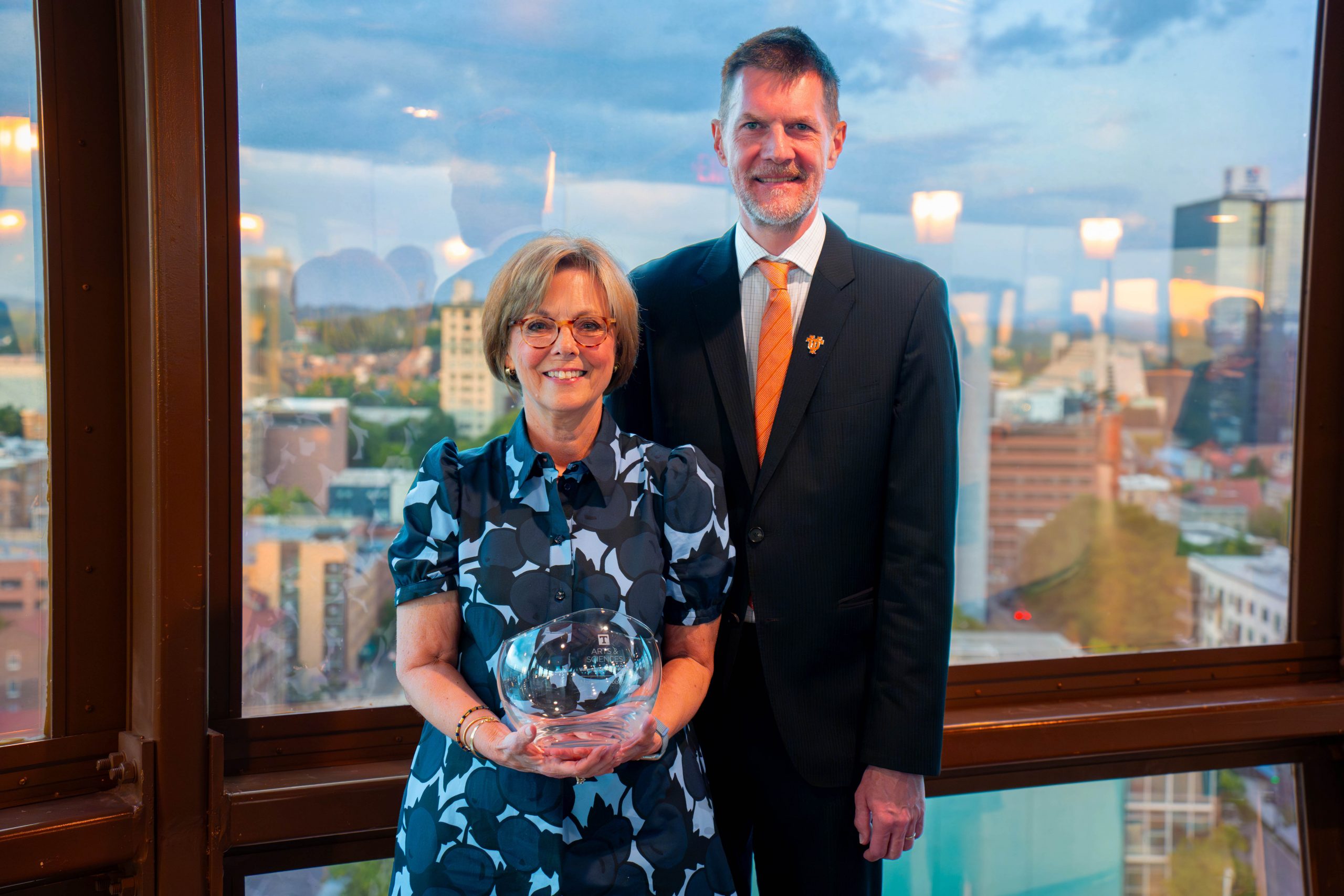 Margie Nichols stands with Interim Executive Dean Robert Hinde holding an award for being Volunteer of the Year.