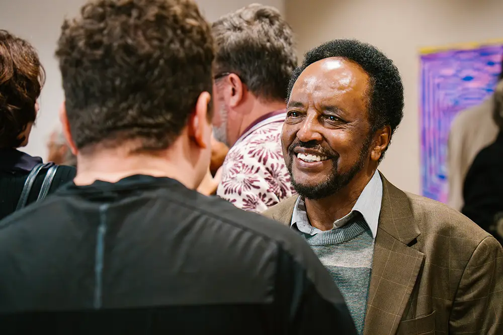 Professor Asafa Jalata chats with another person during the book party about his newly published books.
