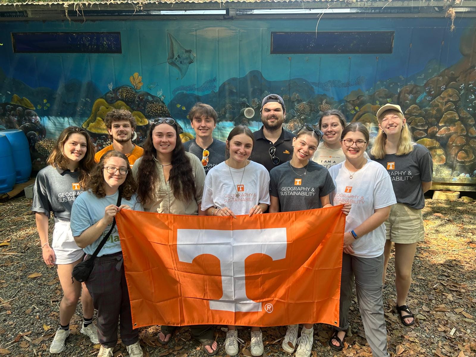 A group of students in the Latin American, Caribbean, and Latinx studies program hold an orange Power T Flag.